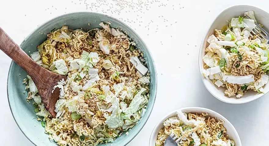 Ein großer Schüssel mit "friss dich dumm salat" aus Nudeln, Chinakohl und Frühlingszwiebeln, daneben zwei kleinere Schüsseln.
