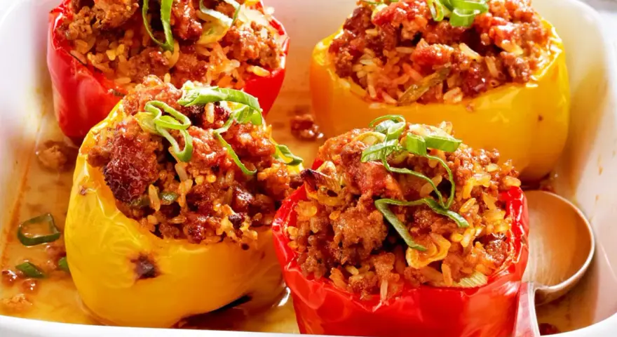 Gefüllte Paprika mit Hackfleisch und Reis, garniert mit Frühlingszwiebeln. Ein Klassiker der Paprika Rezepte.