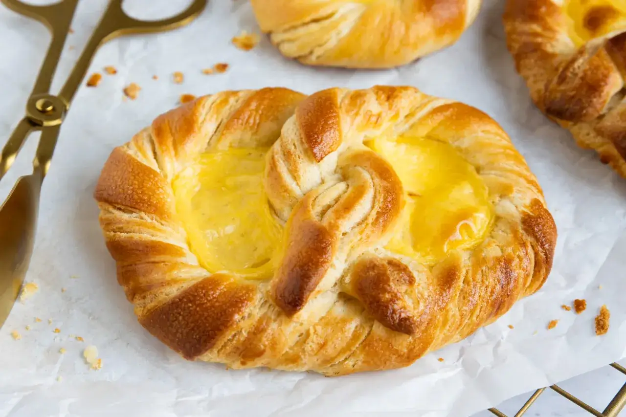 Goldene puddingbrezeln, frisch gebacken, warten auf das puddingbrezel rezept. Ein goldener Zangen liegt daneben.