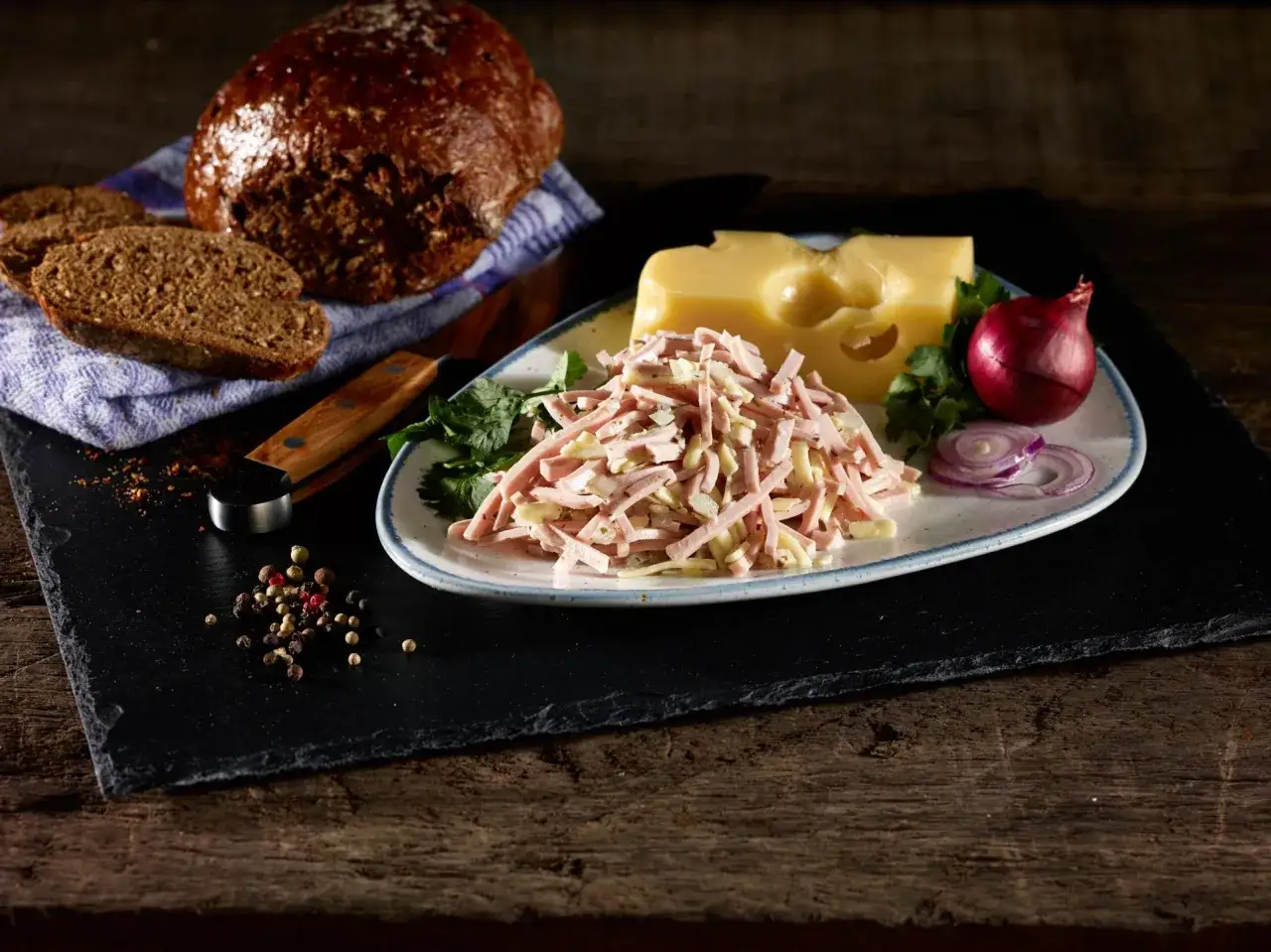 Ein appetitlicher Schweizer Wurstsalat mit K&auml;se, Zwiebeln und Brot.