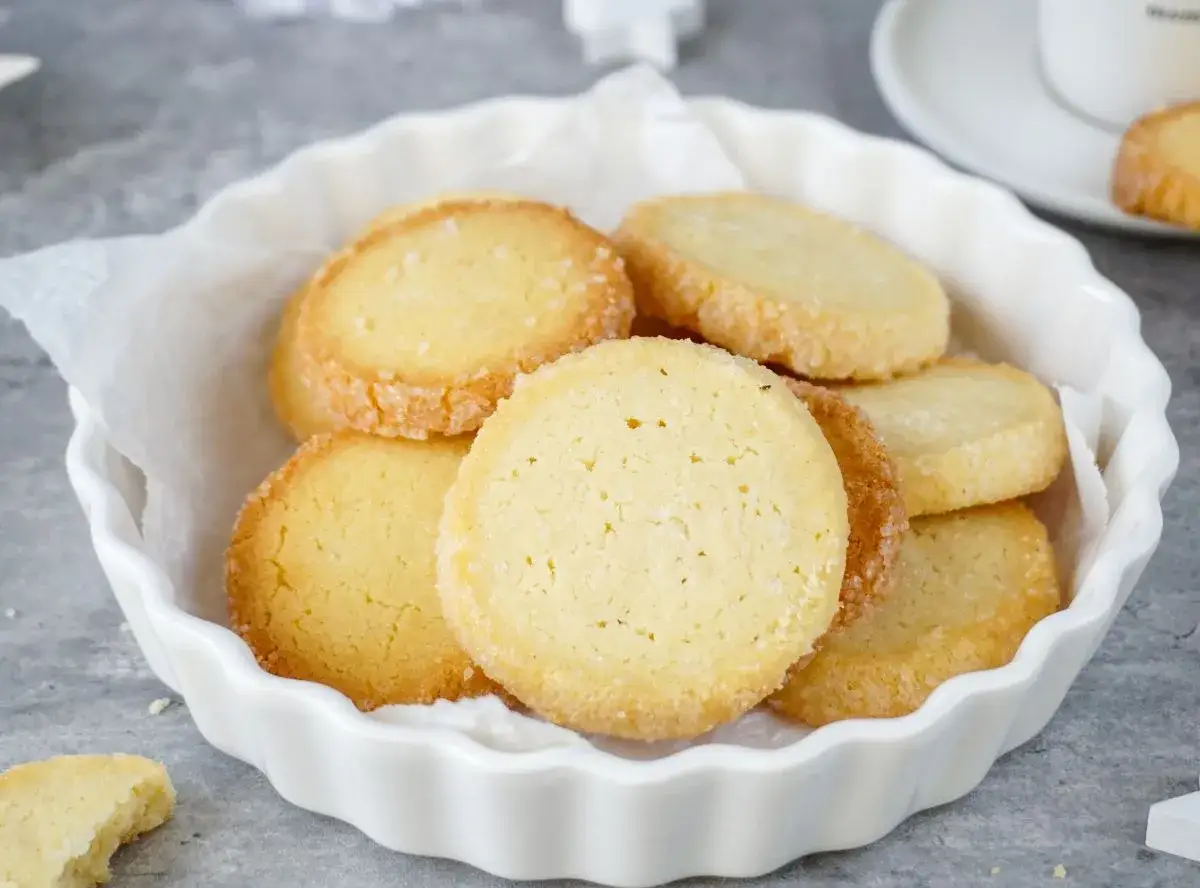Leckere Kekse, die nach einem einfachen Heidesand Rezept gebacken wurden, liegen in einer wei&szlig;en Schale.