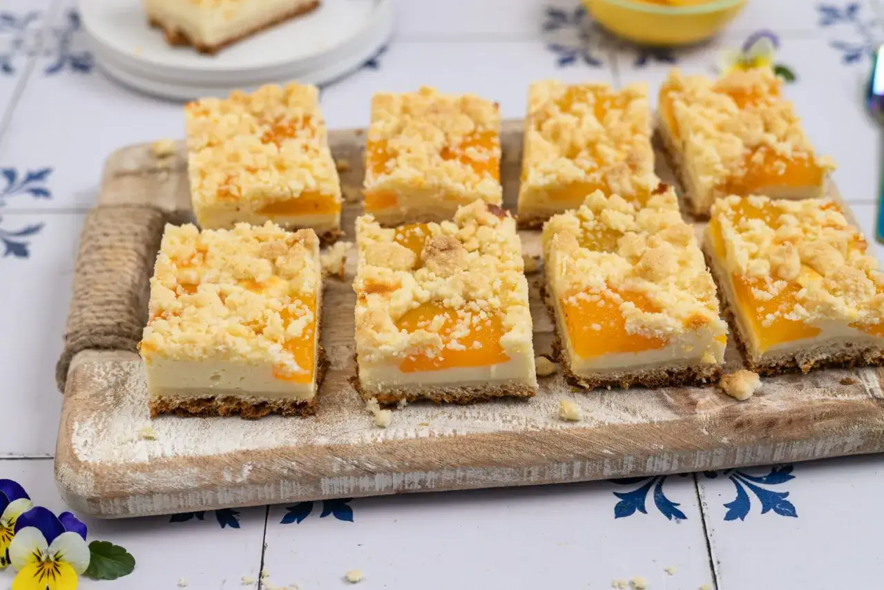 Saftiger aprikosenkuchen mit Streuseln, auf einem Holzbrett angerichtet. Ein Genuss für Augen und Gaumen!