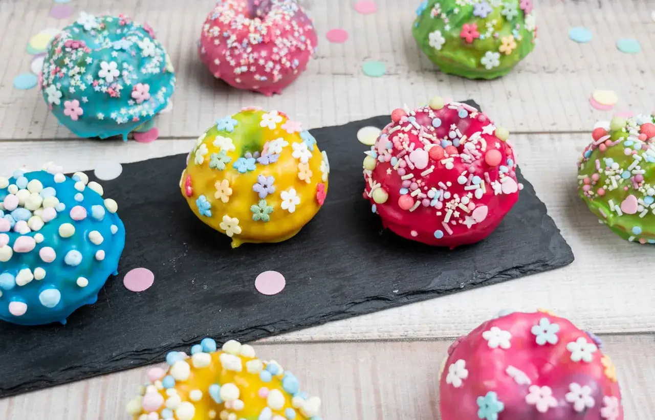Bunte Mini Gugelhupf dekorieren mit Streuseln und Bl&uuml;ten. Ein Fest f&uuml;r die Augen und den Gaumen!