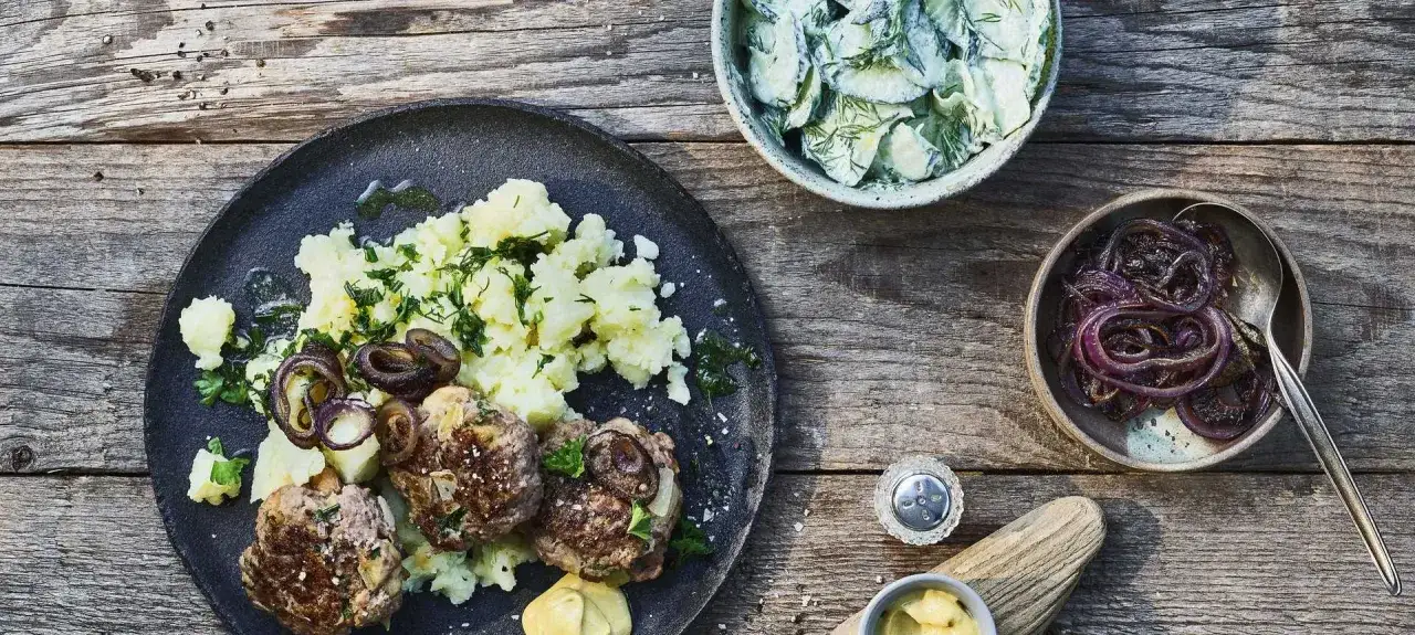 Herzhaftes Buletten Rezept mit Kartoffelbrei, Gurkensalat und karamellisierten Zwiebeln &ndash; ein Klassiker f&uuml;r jeden Tag.