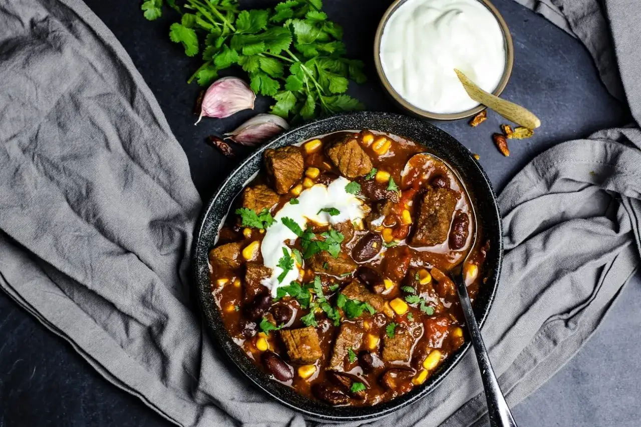 Herzhaftes Chili con Carne mit Rindfleisch, Bohnen und Mais. Ein tolles Gericht f&uuml;r alle, die Bohnen Rezepte lieben. Serviert mit einem Klecks Sauerrahm.