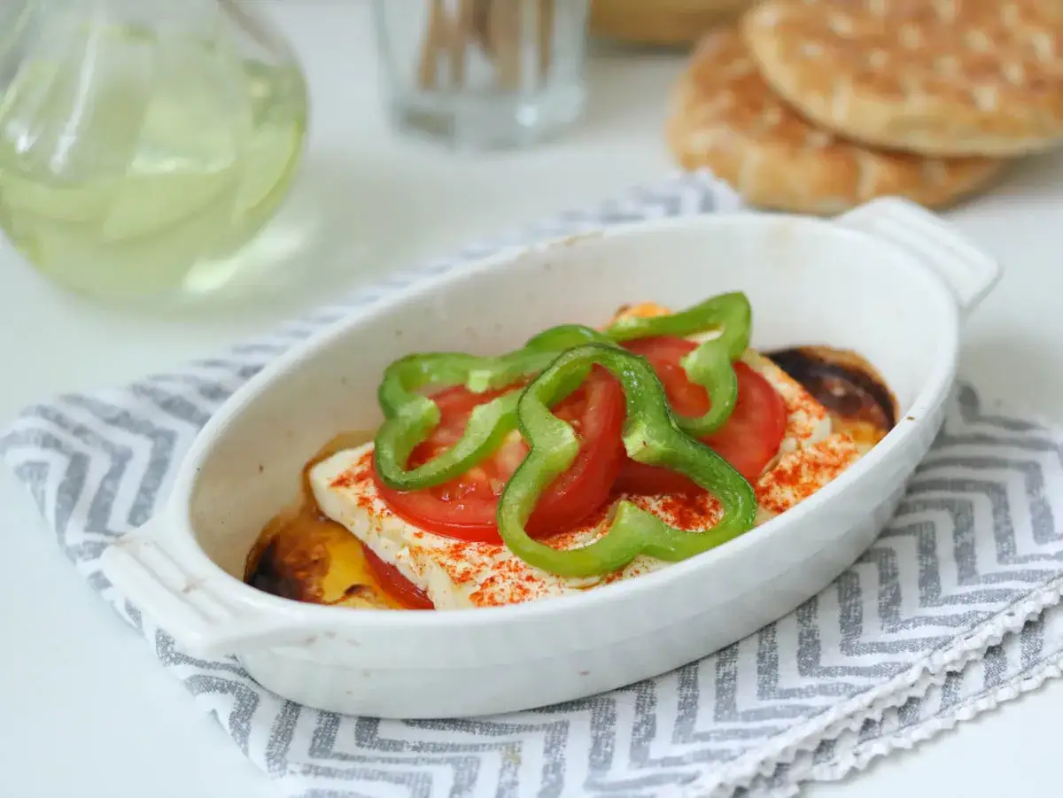 Leckerer gebackener Feta mit Tomaten und Paprika in einer Auflaufform, bereit zum Genie&szlig;en.