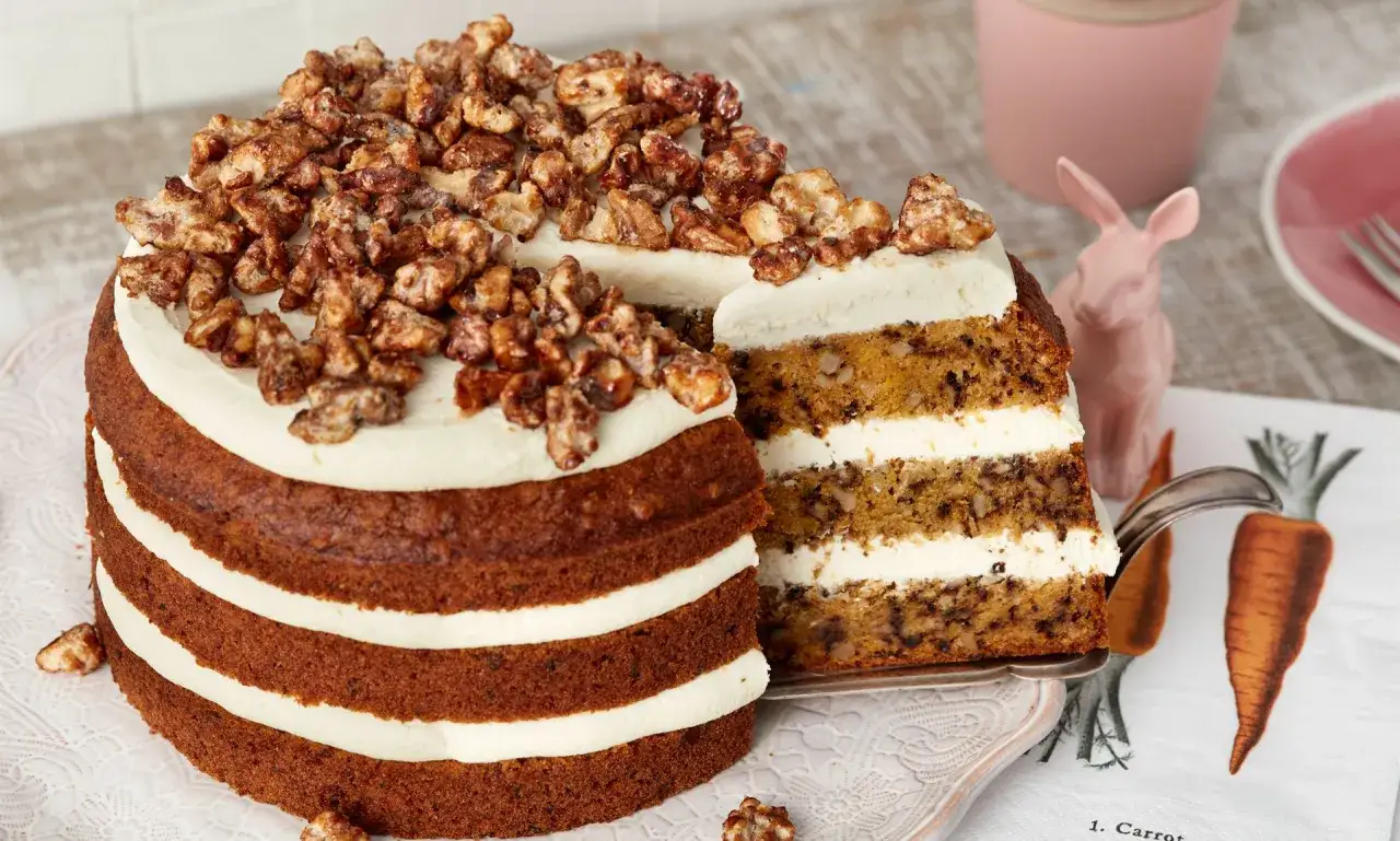 Saftiger Karottenkuchen ohne Zucker, geschichtet mit cremiger Glasur und garniert mit karamellisierten Waln&uuml;ssen. Ein Genuss f&uuml;r alle Sinne!