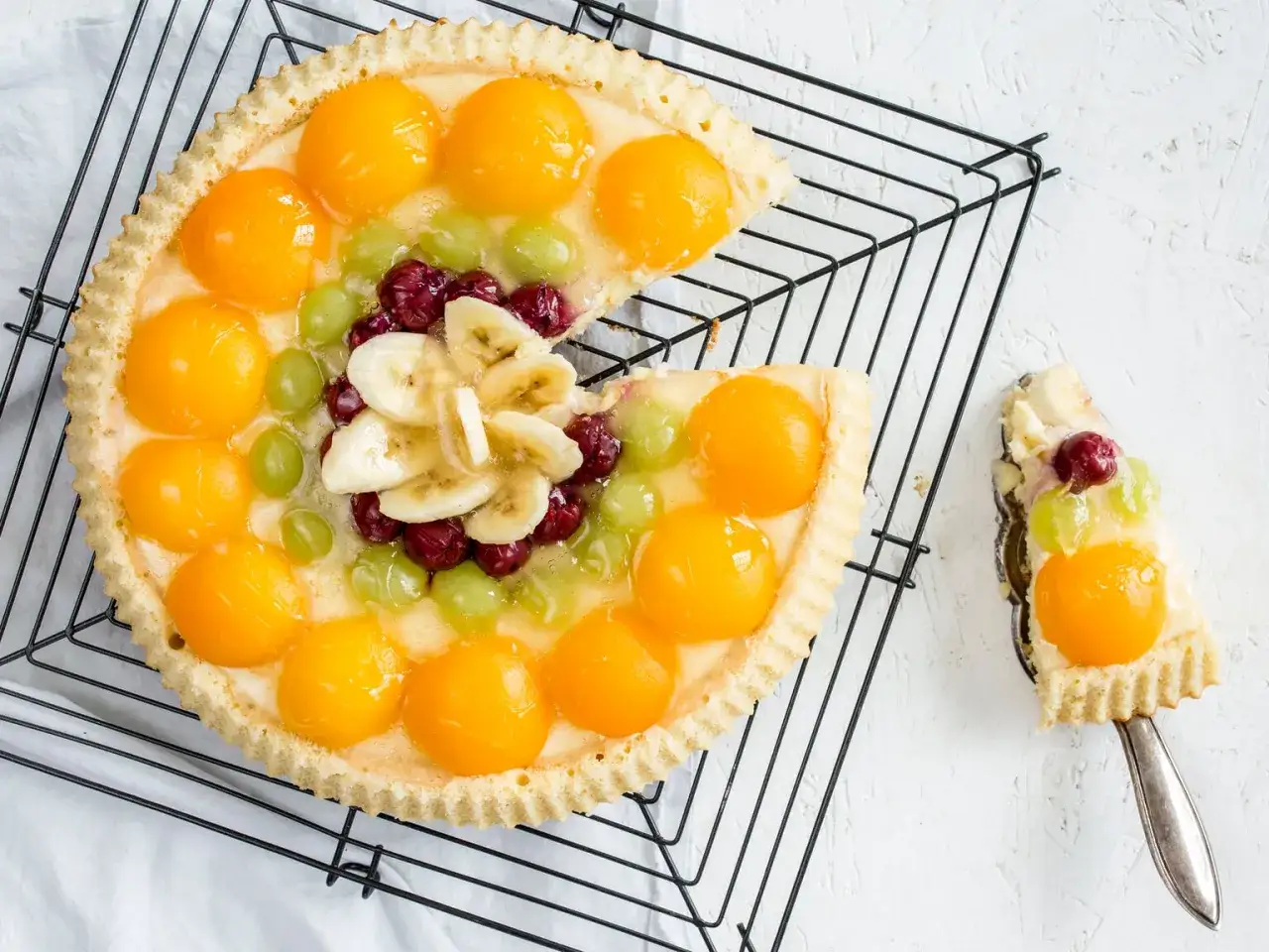 Ein leckerer Obstkuchen mit Aprikosen, Trauben, Kirschen und Bananen. Ein tolles obstkuchen rezept f&uuml;r den Sommer.