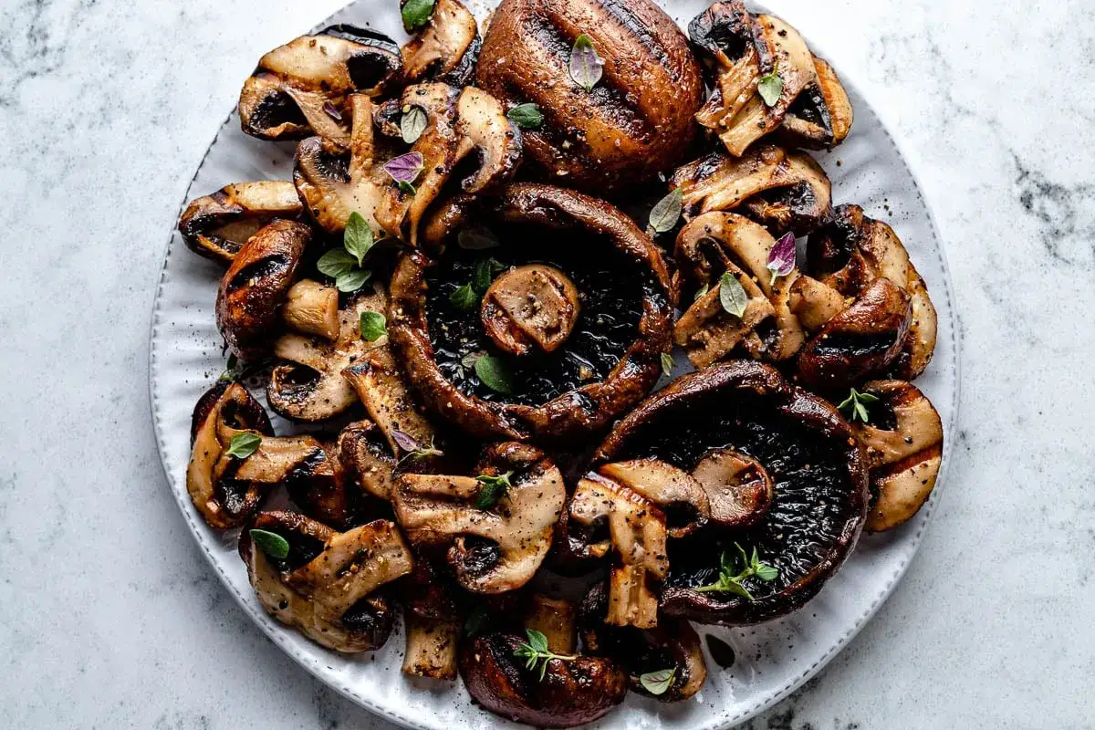 Saftige, gegrillte Champignons, garniert mit frischen Kr&auml;utern, verlocken zum Genuss. Perfekt f&uuml;r jeden Grillabend.