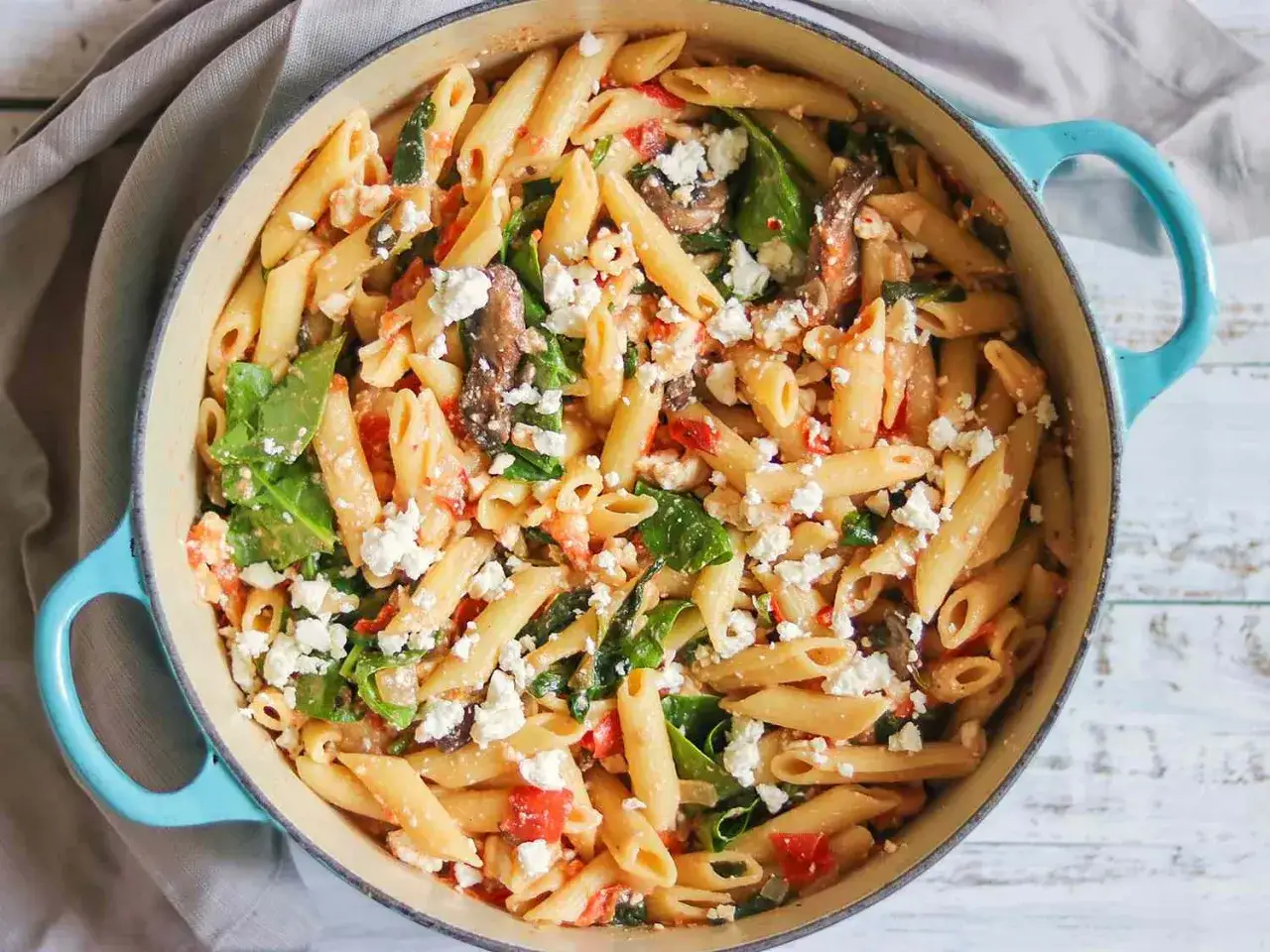 One Pot Pasta mit Feta, Spinat und Tomaten in einem blauen Topf, k&ouml;stlich und einfach zubereitet.