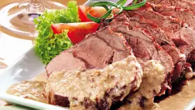 Saftiger Sauerbraten, perfekt für Ihr nächstes Sauerbraten Rezept, serviert mit frischem Salat und Tomaten.