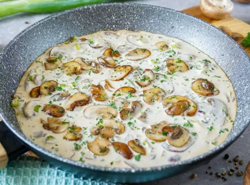 Cremige Champignon-Pfanne, ein köstliches Gericht, das Lust auf mehr Champignons Rezepte macht. Mit frischer Petersilie garniert.